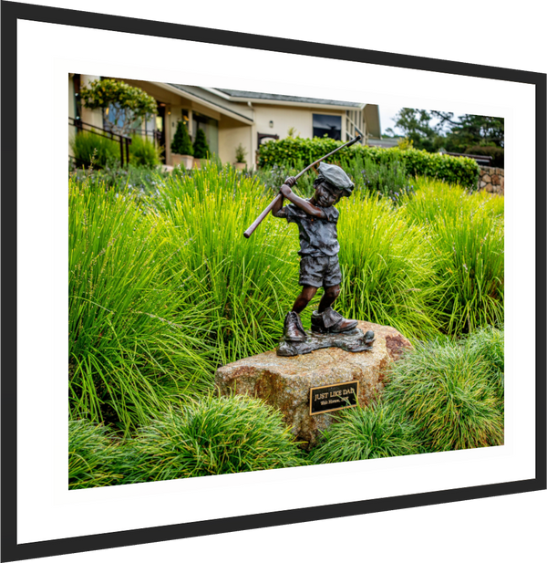 Bronze statue of a boy swinging a golf club, titled "Just Like Dad," near Pebble Beach pro shop.