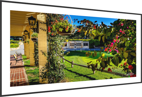 View from Pebble Beach promenade showcasing the Champions of Pebble Beach monument and vibrant flowers nearby.