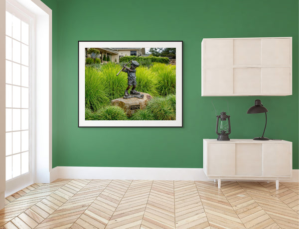 Statue of a boy golfer at Pebble Beach, capturing the spirit of "Just Like Dad" in a vibrant green setting.