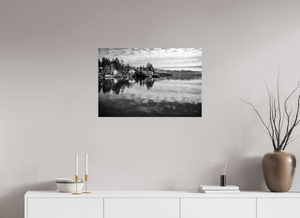 Tranquil scene of Lake Tahoe in black and white, showcasing cozy cabins, pines, and serene reflections. Serenity on the Water – Lake Tahoe in Black and White.