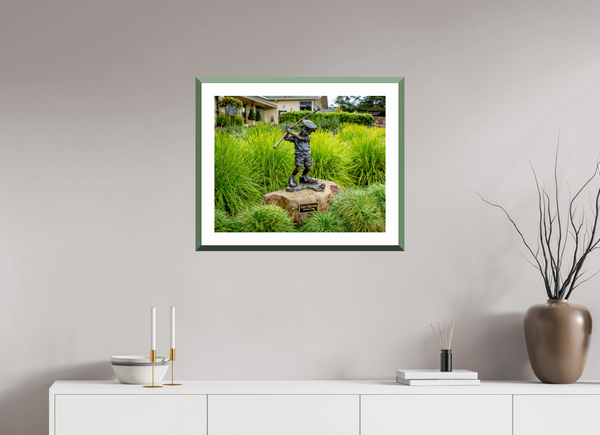 A bronze statue of a boy swinging a golf club, embodying the spirit of "Just Like Dad" at Pebble Beach.