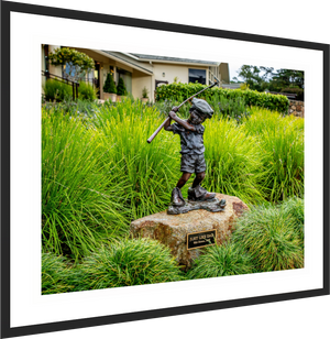 Bronze statue of a boy swinging a golf club, titled "Just Like Dad," near Pebble Beach pro shop.